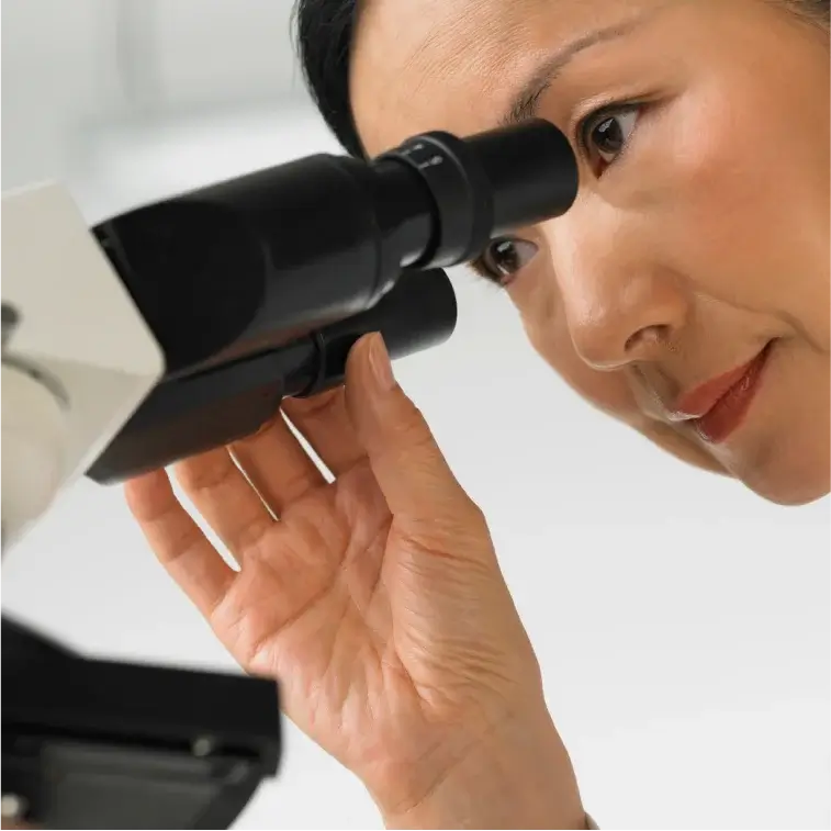 Chinese Woman at BCM Looking into Microscope Doing Medical Research